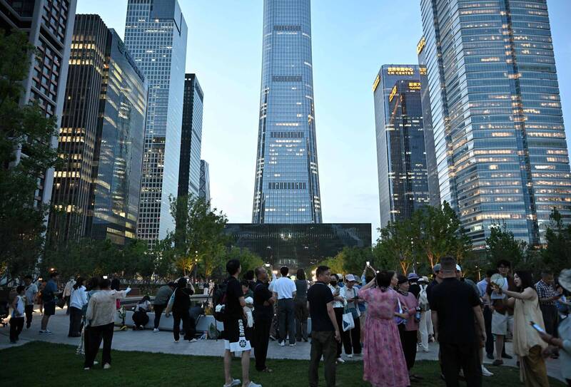一架轻航机26日撞击北京中信大厦(Citic Tower),许多民众聚集在附近。 (法新社) 一架轻航机26日撞击北京中信大厦(Citic Tower),许多民众聚集在附近。 (法新社)